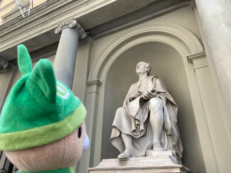 Sumi looking up at a marble statue in a niche