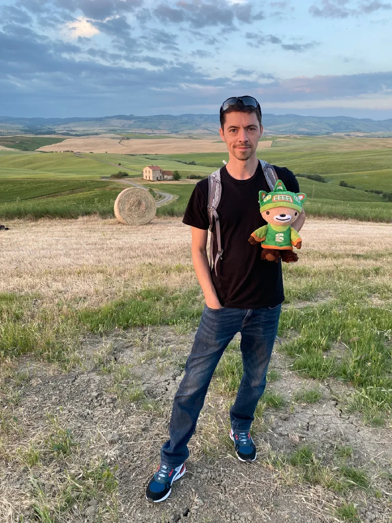 Nicholas holding Sumi with rolling Tuscan hills at sunset