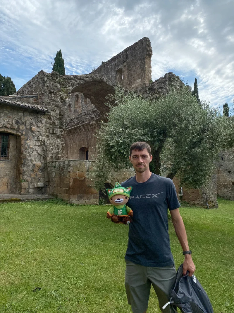 Sumi Bear at the abbey ruins with crumbling arches and cypress trees