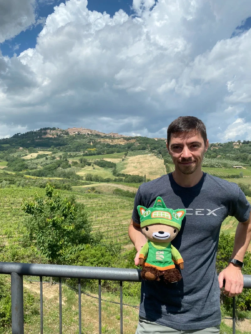 Sumi at vineyard railing with hilltop town in background