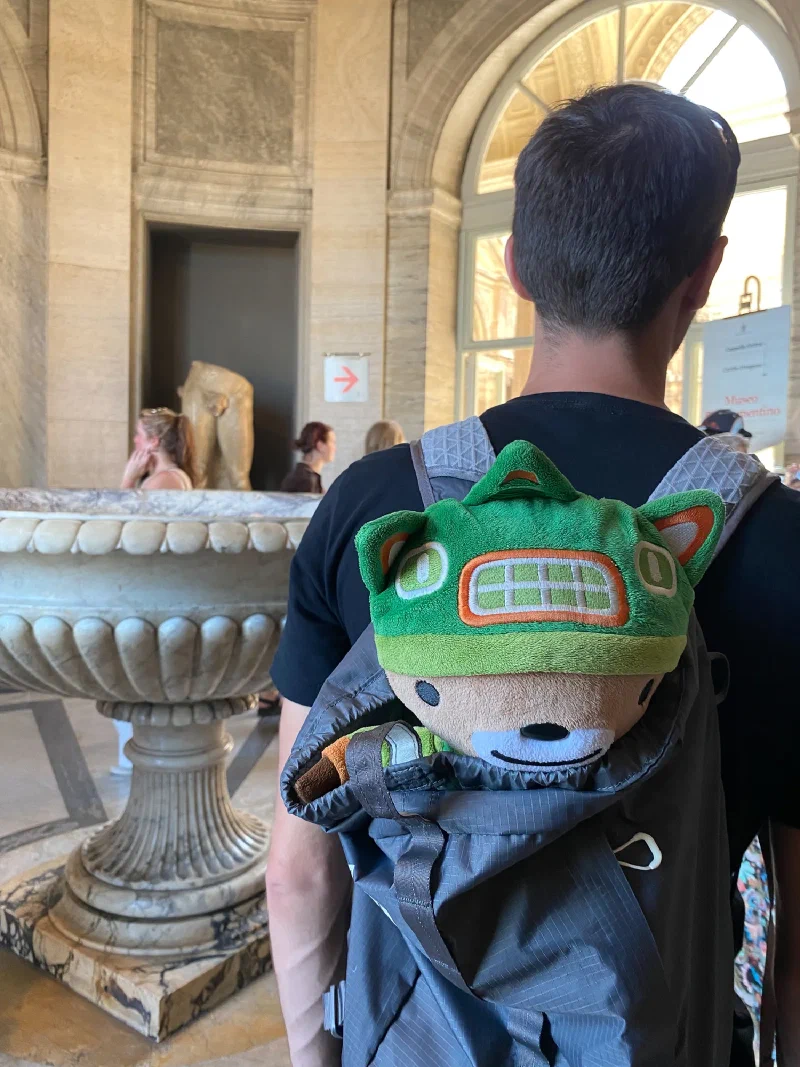 Sumi in a backpack with signs pointing to the Sistine Chapel