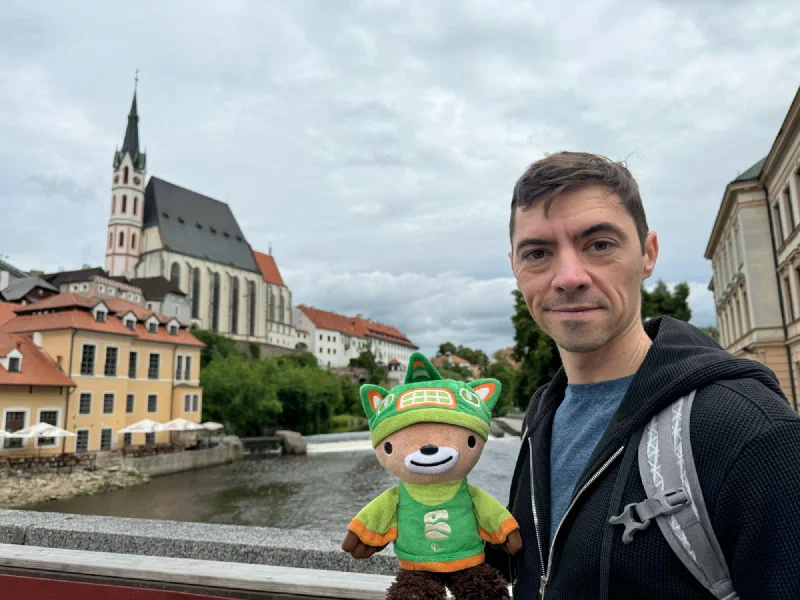 Nicholas and Sumi Bear on a bridge with the church behind