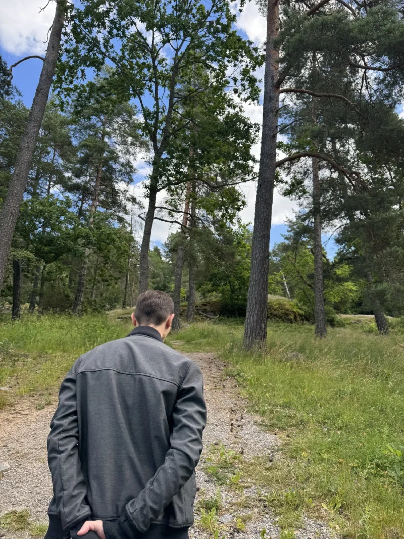Nicholas walking down a forest path near Sundbyholm