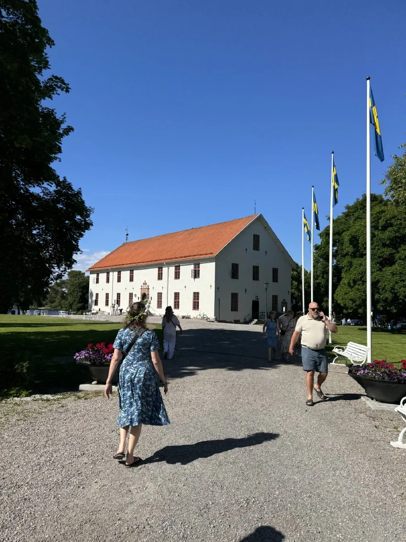 Sundbyholm Castle with Swedish flags and visitors on Midsommar