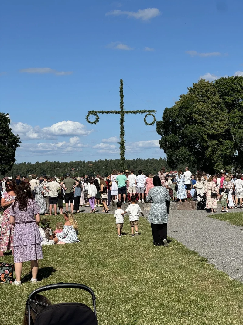 Midsommar maypole celebration with crowd on the castle lawn