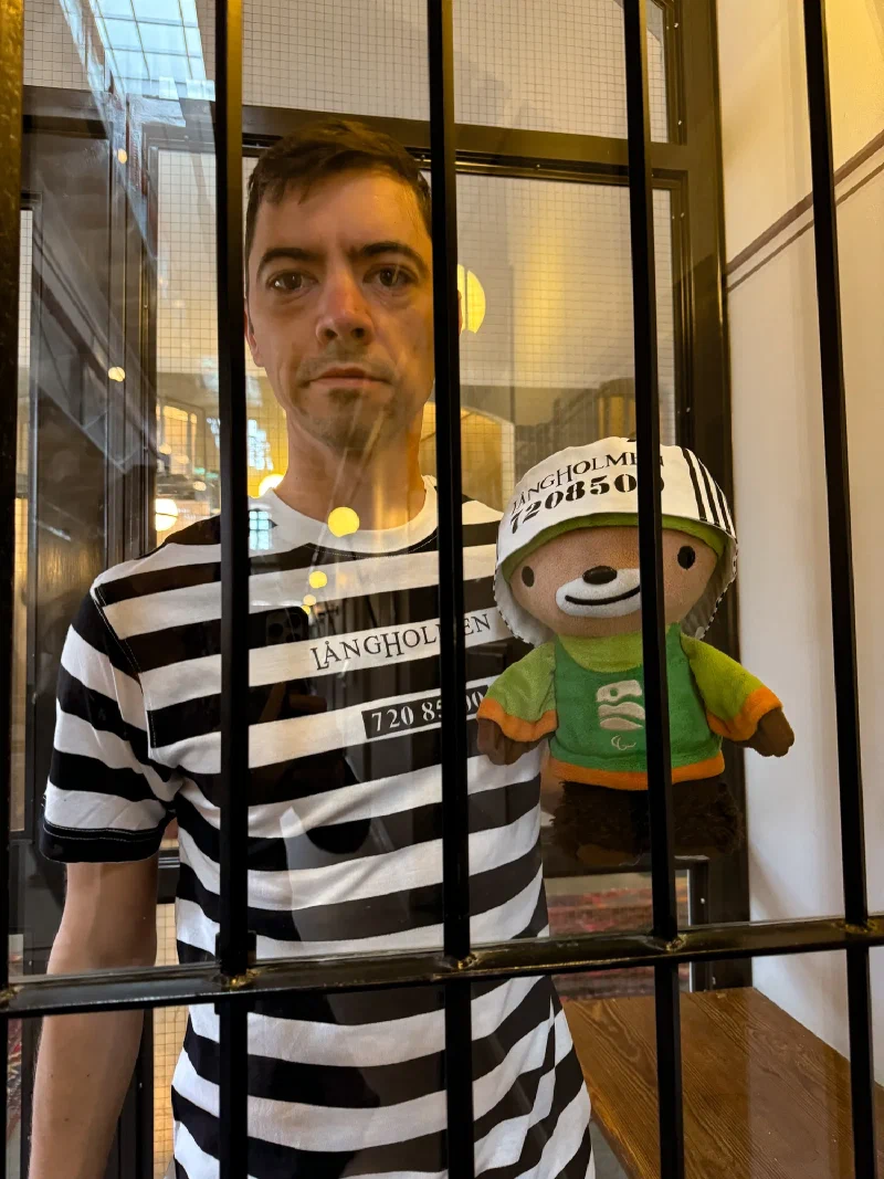 Close-up of Nicholas and Sumi behind jail bars