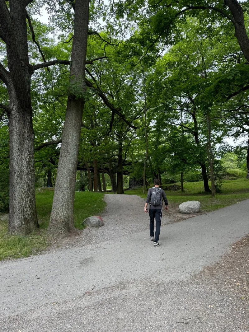 Nicholas walking down a tree-lined path on Långholmen island