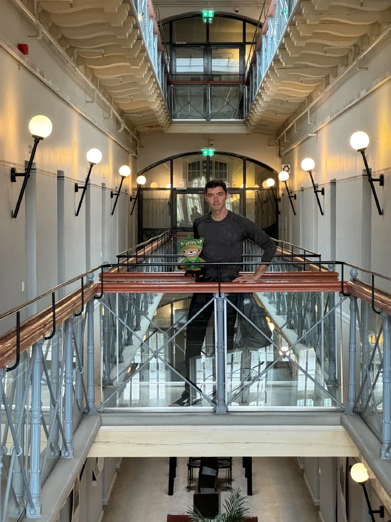 Nicholas and Sumi on the upper-level bridge of the prison atrium