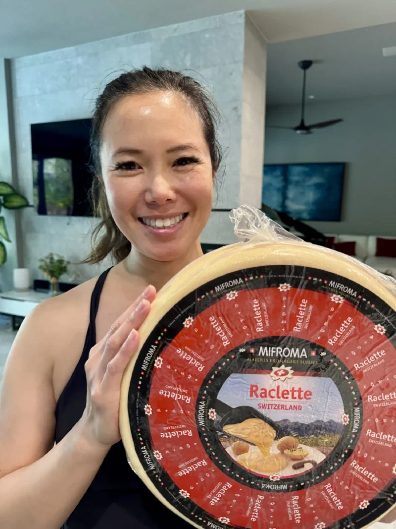 Pokin proudly holding up a giant wheel of Mifroma Swiss Raclette cheese