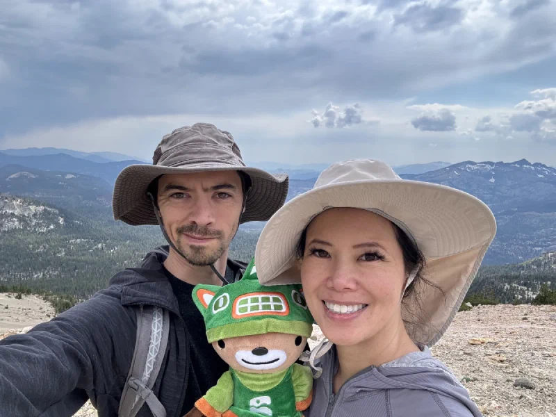 Selfie of Nicholas, Pokin, and Sumi Bear at a mountain summit with Sierra Nevada panorama