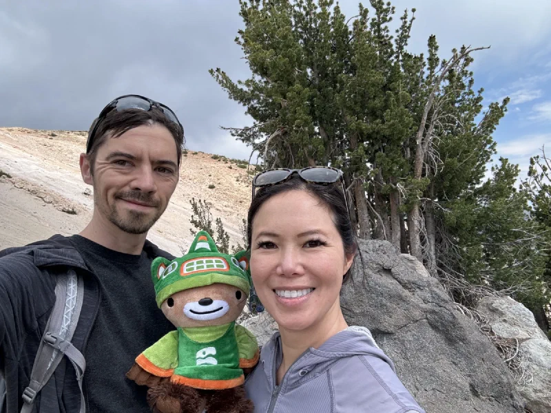 Selfie of Nicholas, Pokin, and Sumi Bear on a sandy mountain slope near wind-beaten trees