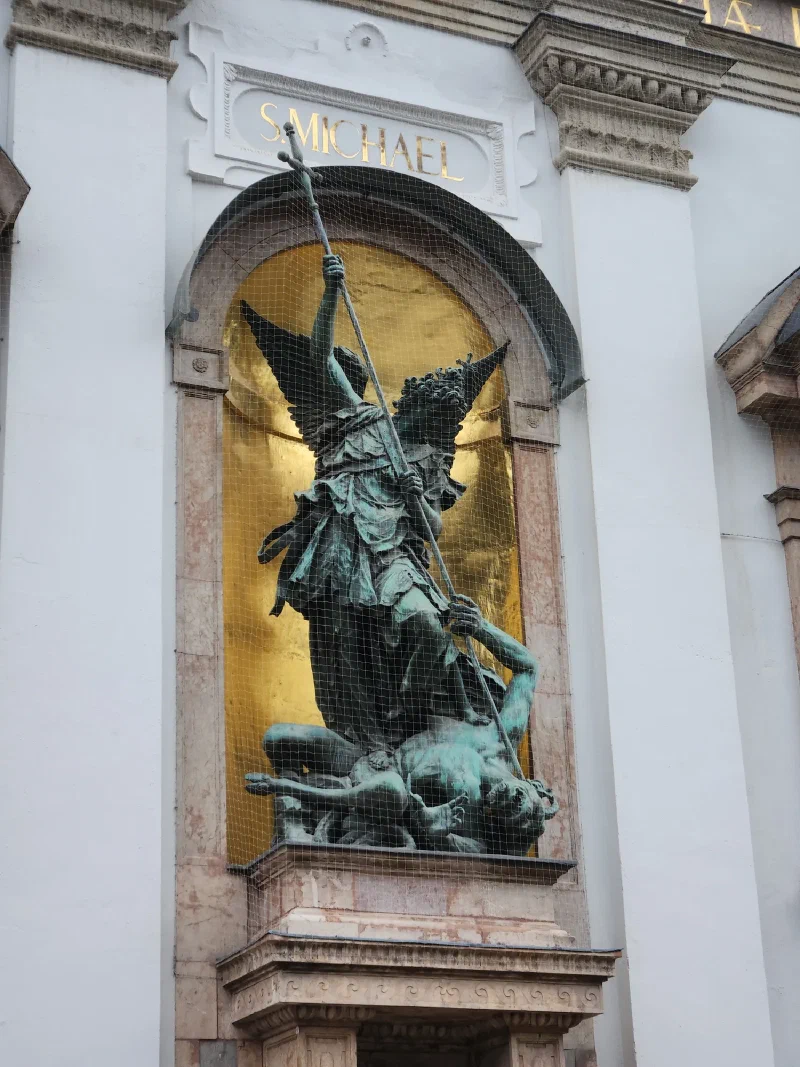 Bronze statue of Saint Michael slaying a demon on the facade of St. Michael's Church in Munich