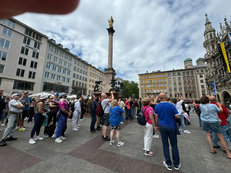 Crowd gathered around Mariensäule in Marienplatz with Munich landmarks in background