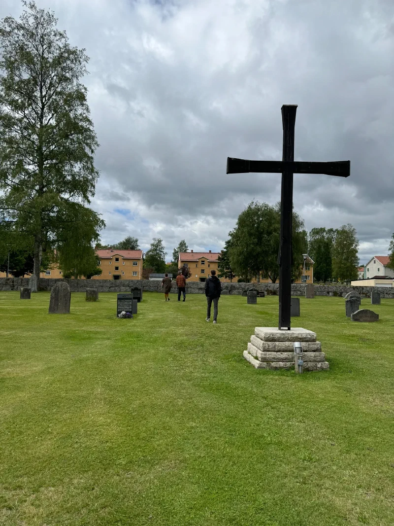 Family walking through Laxå cemetery under gray clouds