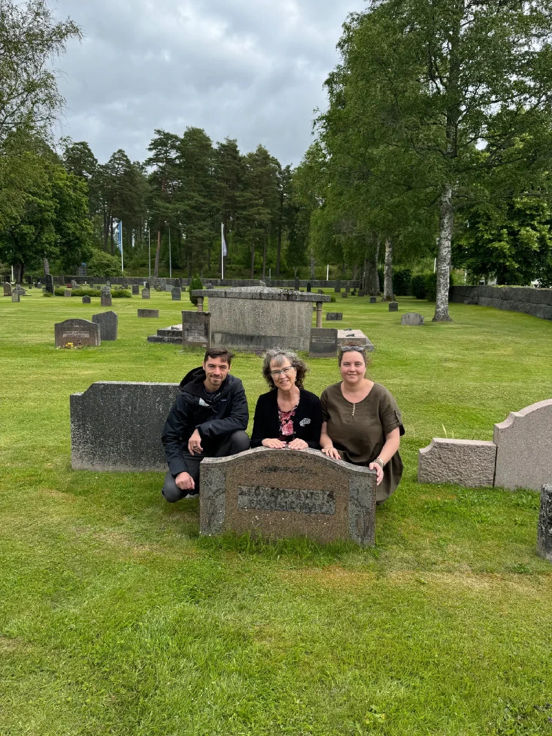 Nicholas, his mom, and Anna kneeling at family gravestone