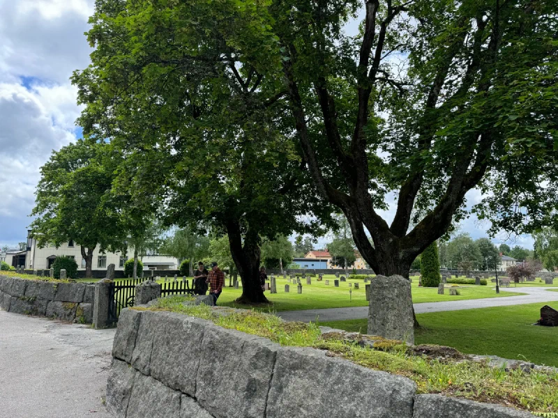 Cemetery entrance with stone wall and iron gate