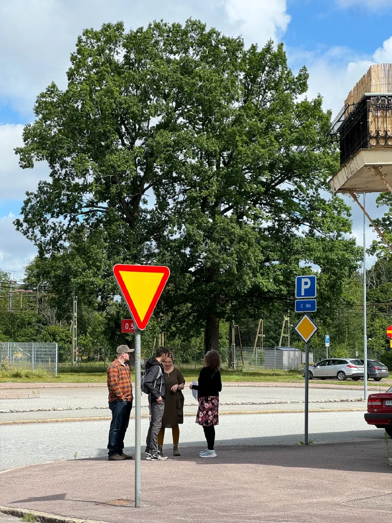 Family gathered under a tree in Laxå comparing notes