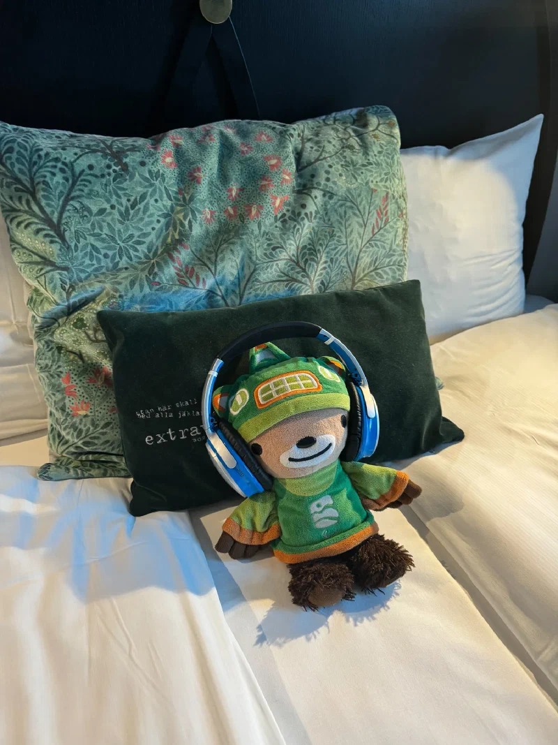 Sumi wearing headphones on the hotel bed