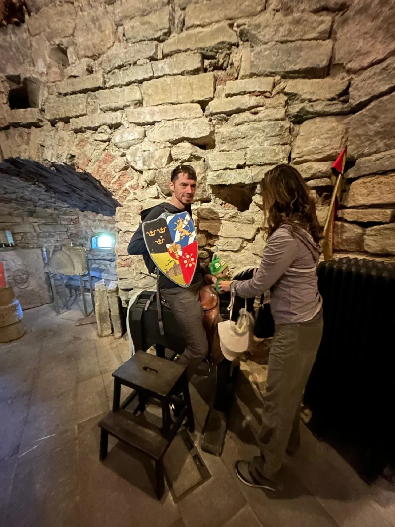 Nicholas with shield while Pokin helps Sumi onto wooden horse