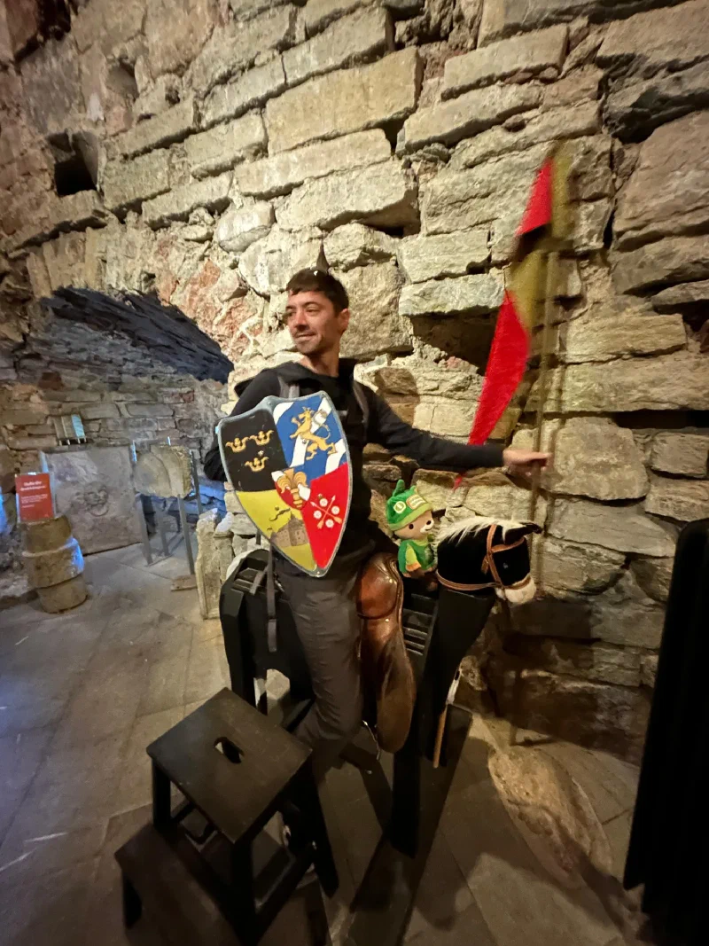 Nicholas with shield and lance beside wooden horse with Sumi