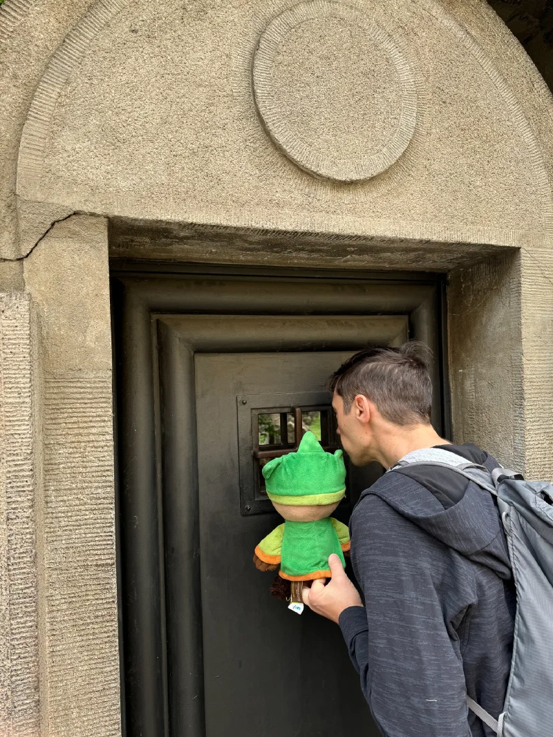 Nicholas peeking through a small window in a door