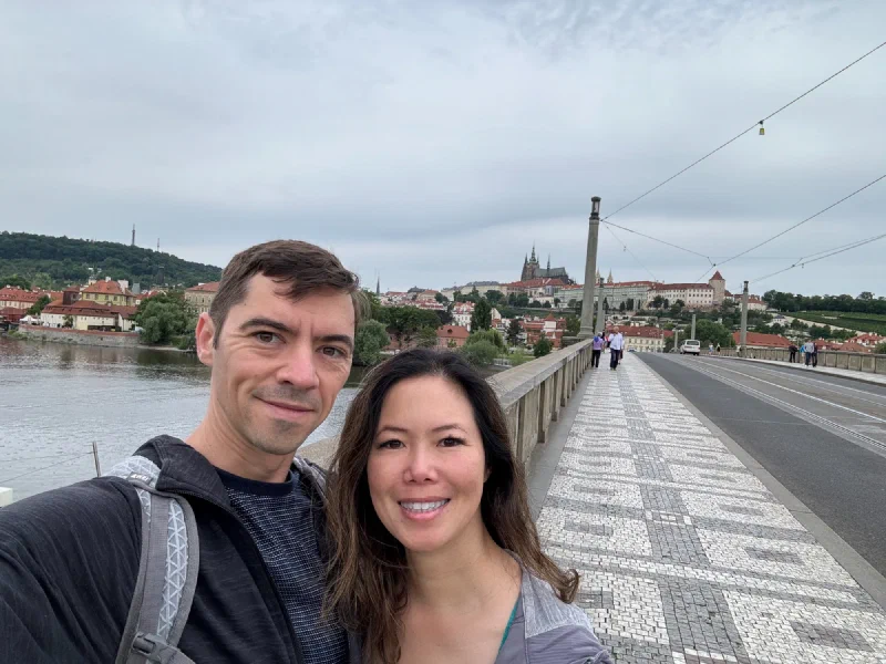 Nicholas and Pokin on a Prague bridge with the castle behind