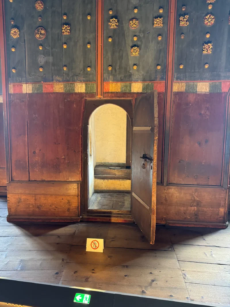 Hidden medieval latrine behind ornate paneled door in the fortress