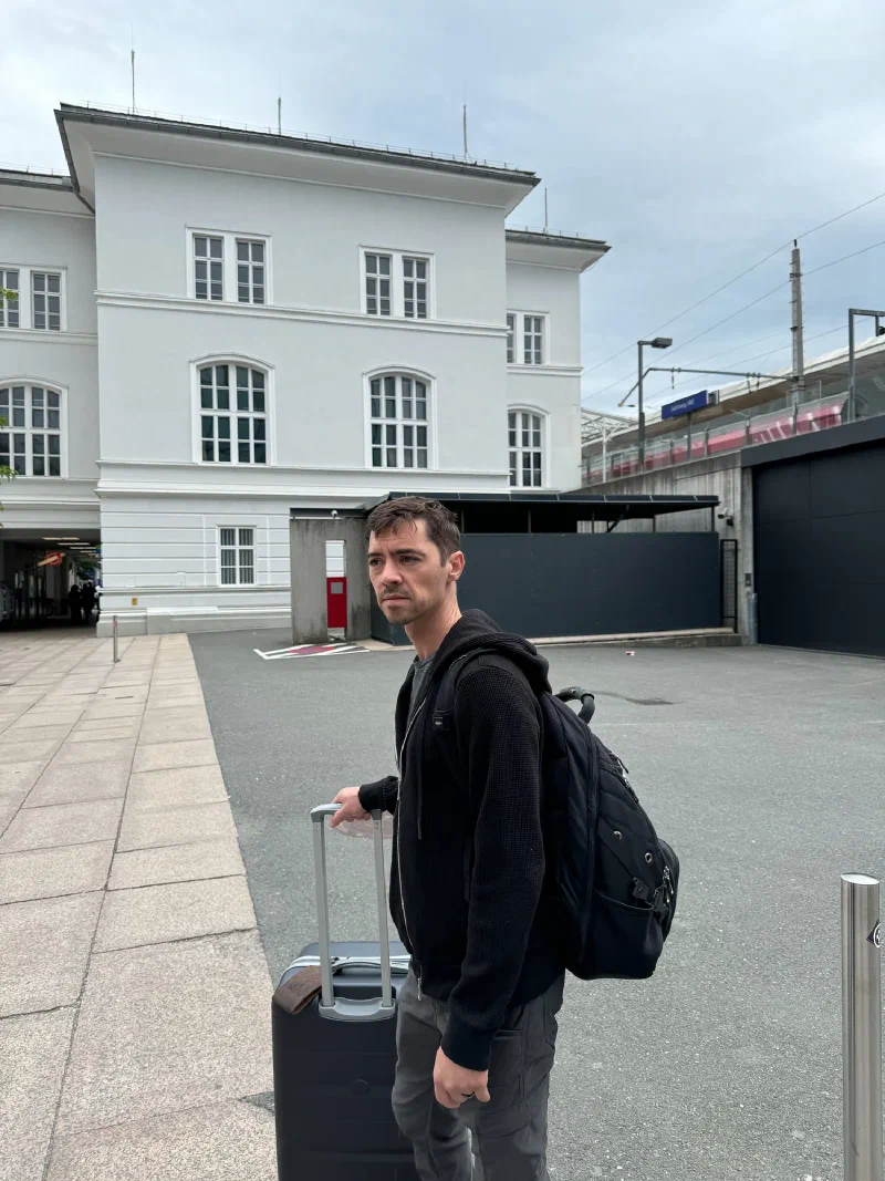 Nicholas at Salzburg train station with luggage ready to depart