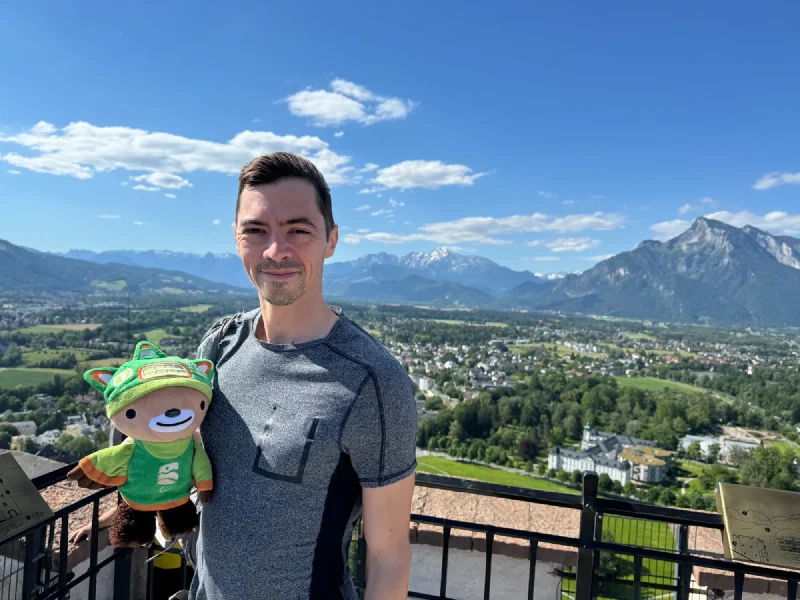 Nicholas holding Sumi at the fortress viewing terrace with mountain identification plaques