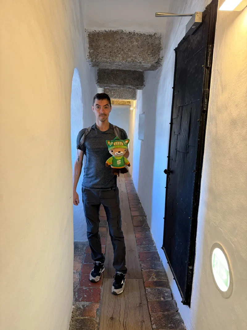 Narrow whitewashed stone corridor with heavy iron-studded door inside Hohensalzburg