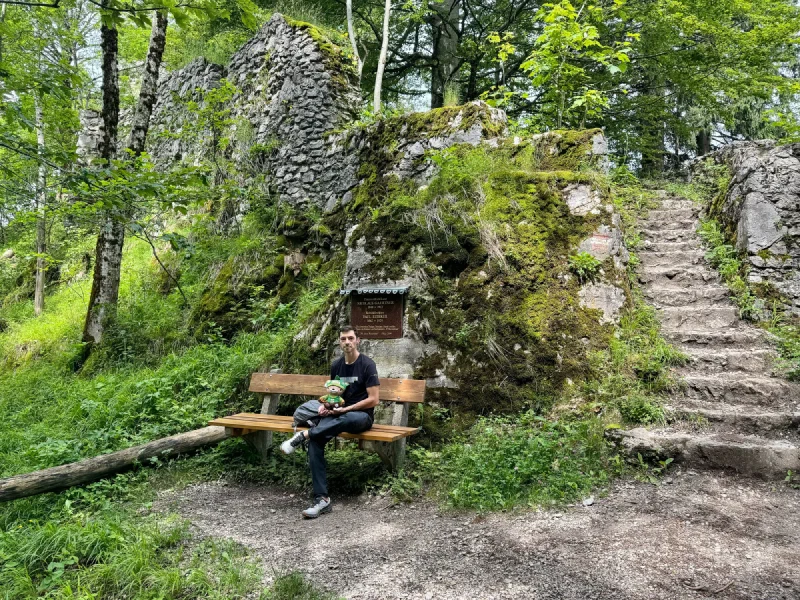 Nicholas with Sumi at a mossy forest ruin bench with stone steps
