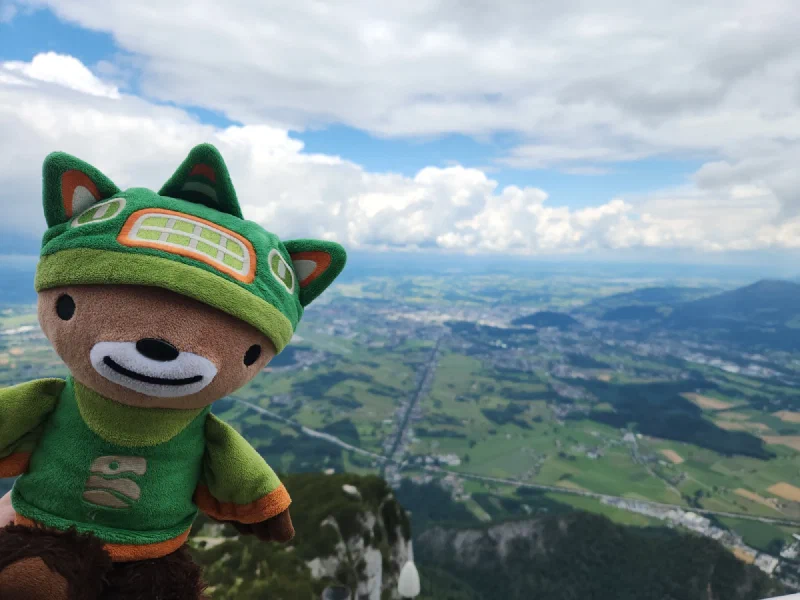 Sumi Bear held up on the Untersberg ridge with the valley behind