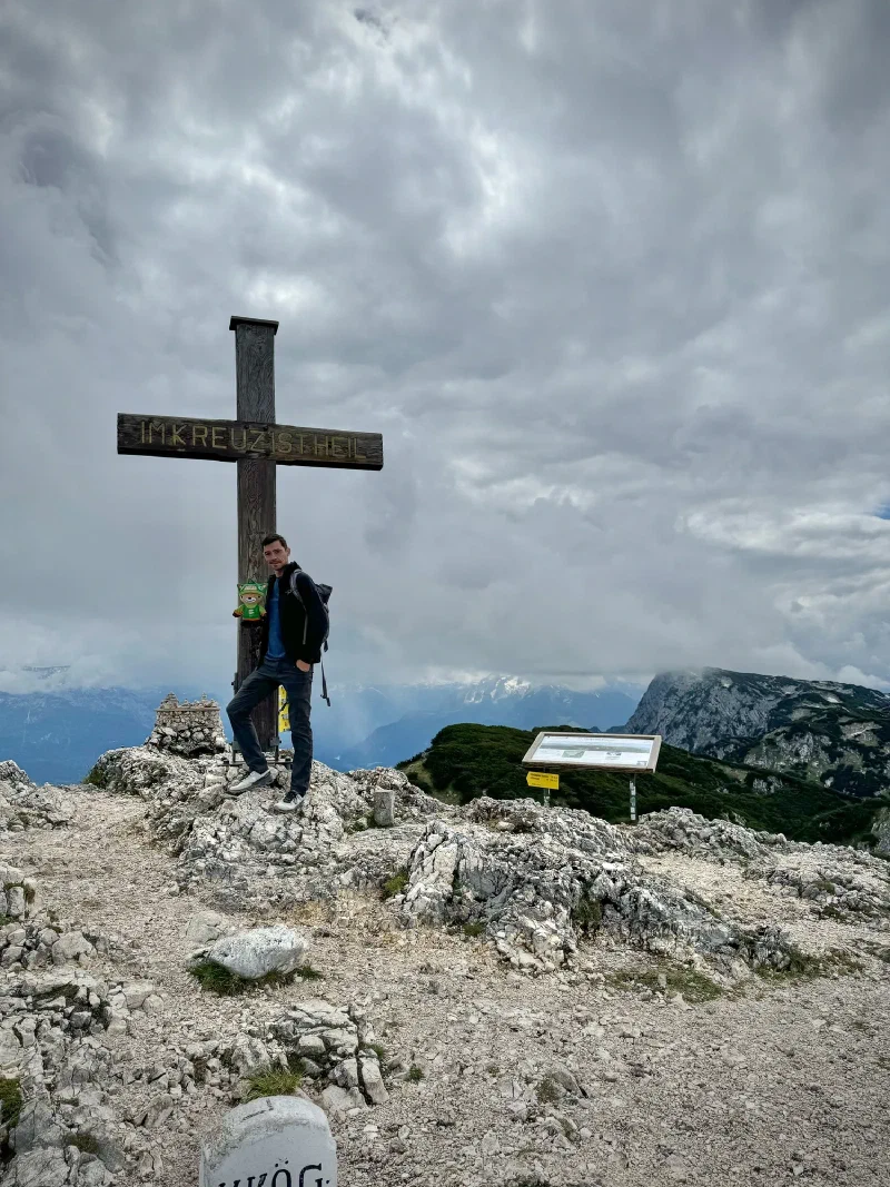 Nicholas and Sumi at the Untersberg summit cross under stormy skies