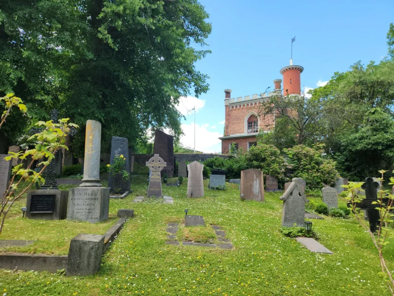 Peaceful Stockholm cemetery with wildflowers and brick turret building