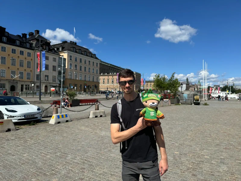 Nicholas holding Sumi in open plaza near Stockholm harbor