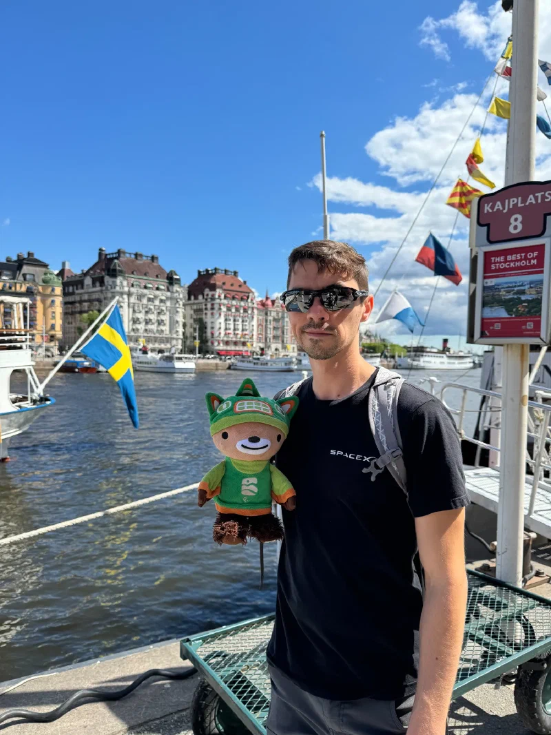 Nicholas holding Sumi at Nybrokajen dock with Swedish flag