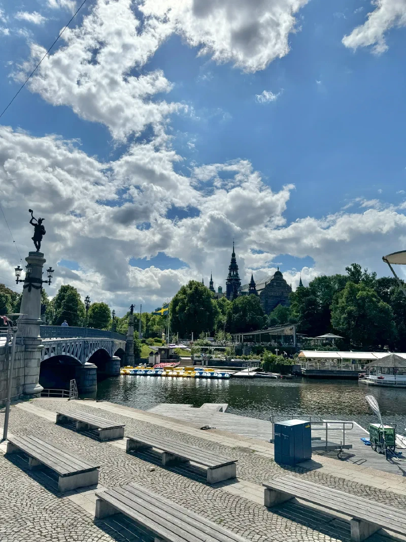 Stockholm waterfront with bridge, statue column, and dramatic clouds