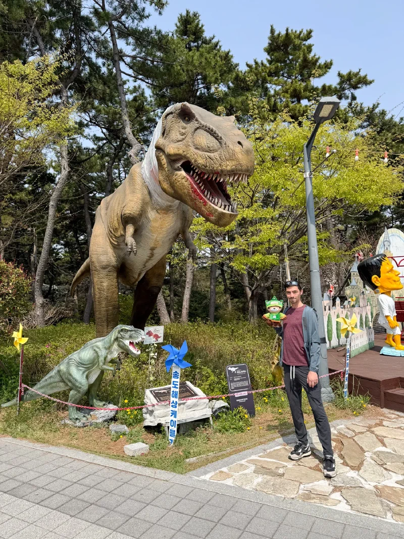Nicholas and Sumi posing with a T-Rex statue