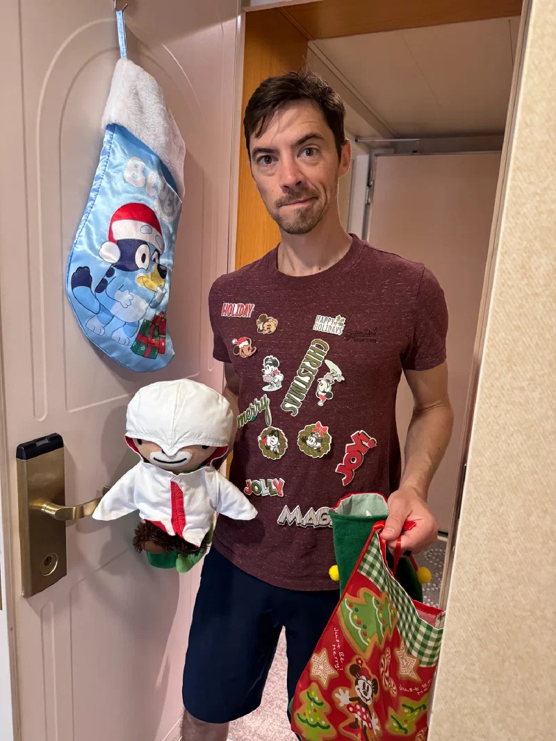 Nicholas in cruise hallway covered in Disney Christmas stickers, holding Sumi