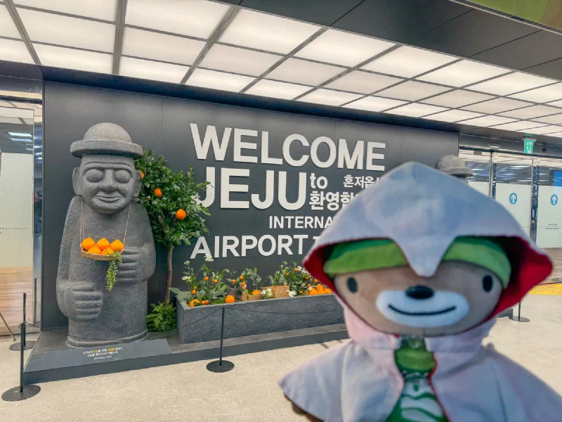 Sumi posing with the dol hareubang statue at Jeju International Airport
