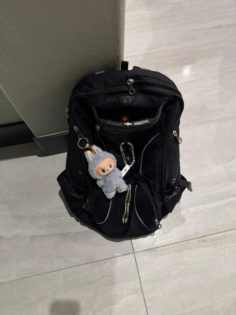 Labubu clipped to Nicholas's bag