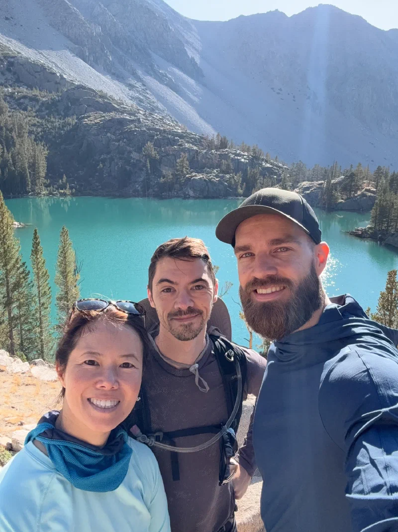 Three hikers selfie at the turquoise lake