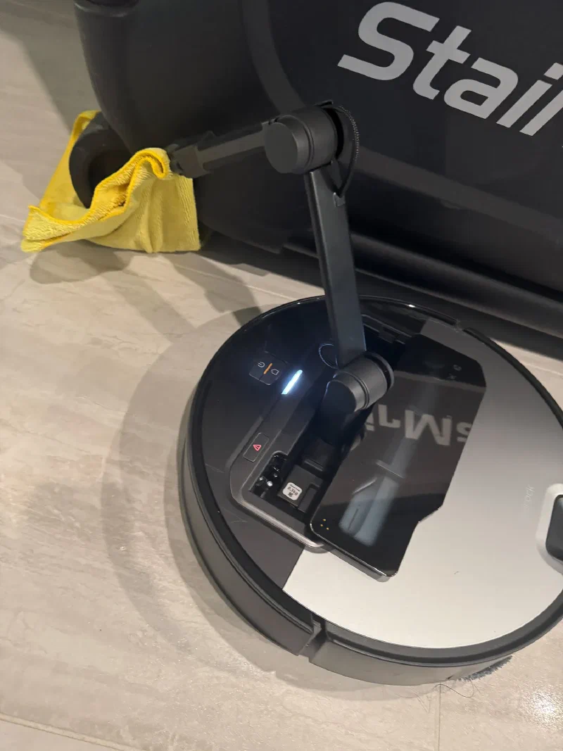 Roborock's arm reaching for the rag under the StairMaster
