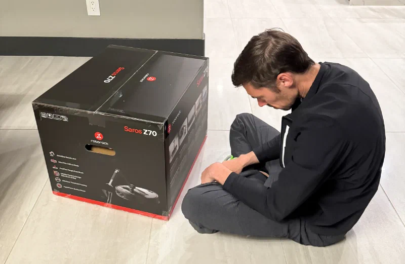 Nicholas sitting next to the Roborock Saros Z70 box
