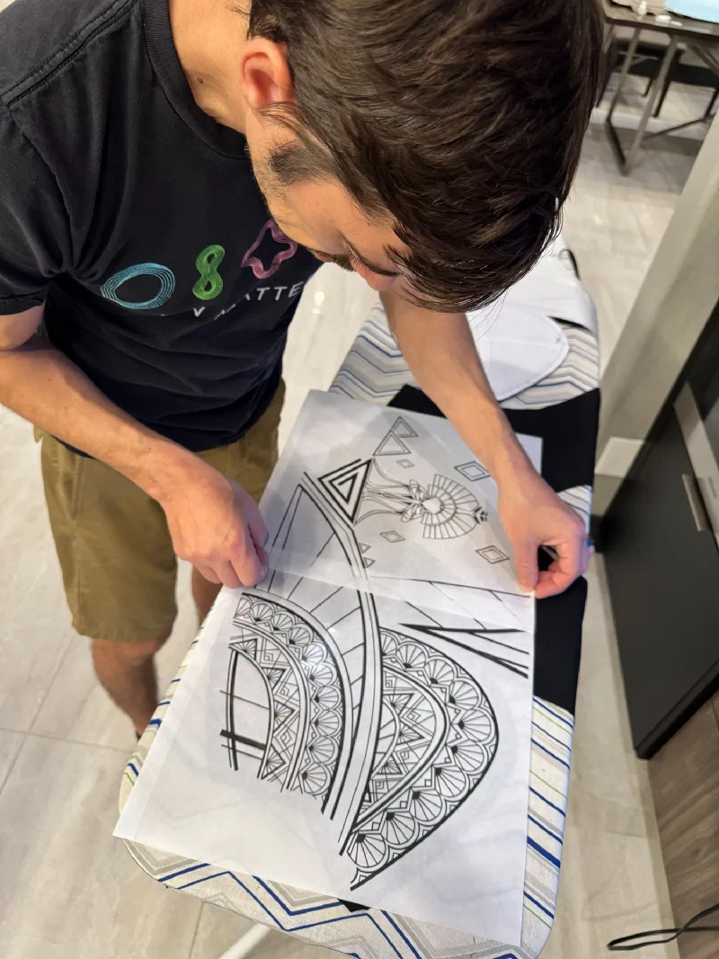 Nicholas ironing transfer patterns onto black fabric