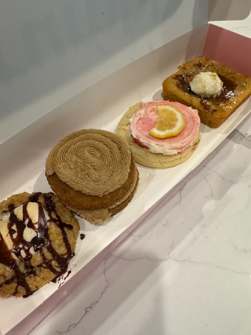Four Crumbl cookies in a pink box