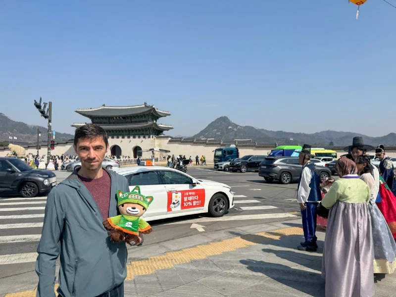 Sumi at Gwanghwamun Gate with people in hanbok