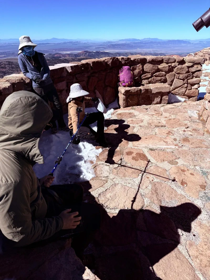 Eric in the stone shelter at Brian Head Peak with shadows that resemble Darth Vader and lightsabers
