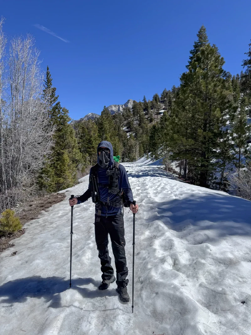 Nicholas on a snowy trail with trekking poles and face covered