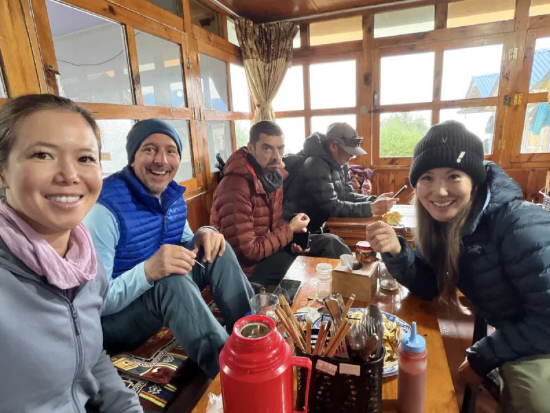 The group around a table in the foggy restaurant, Nicholas looking displeased
